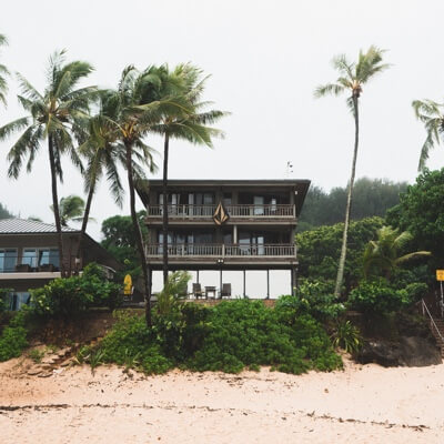 house on the beach between palm trees